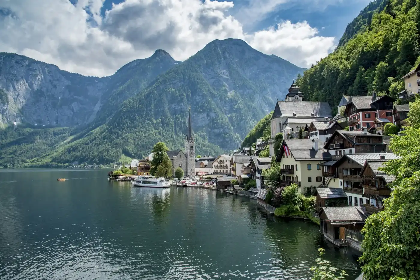 Hallstatt village and church beside the lake under green Alpine mountains