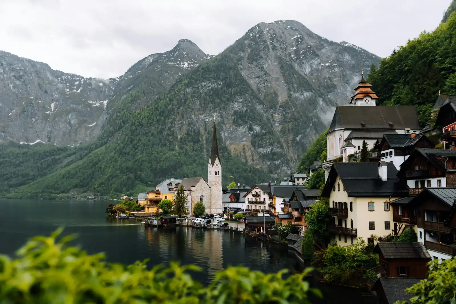 Hallstatt village beside Lake Hallstatt with steep Alpine mountains behind it