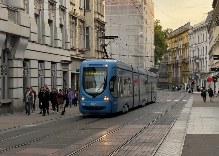 Blue Zagreb tram travelling through a street lined with historic buildings