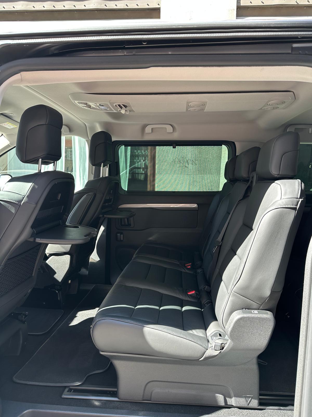 Side view inside the Movira VIP van showing leather seats and fold-out passenger tables